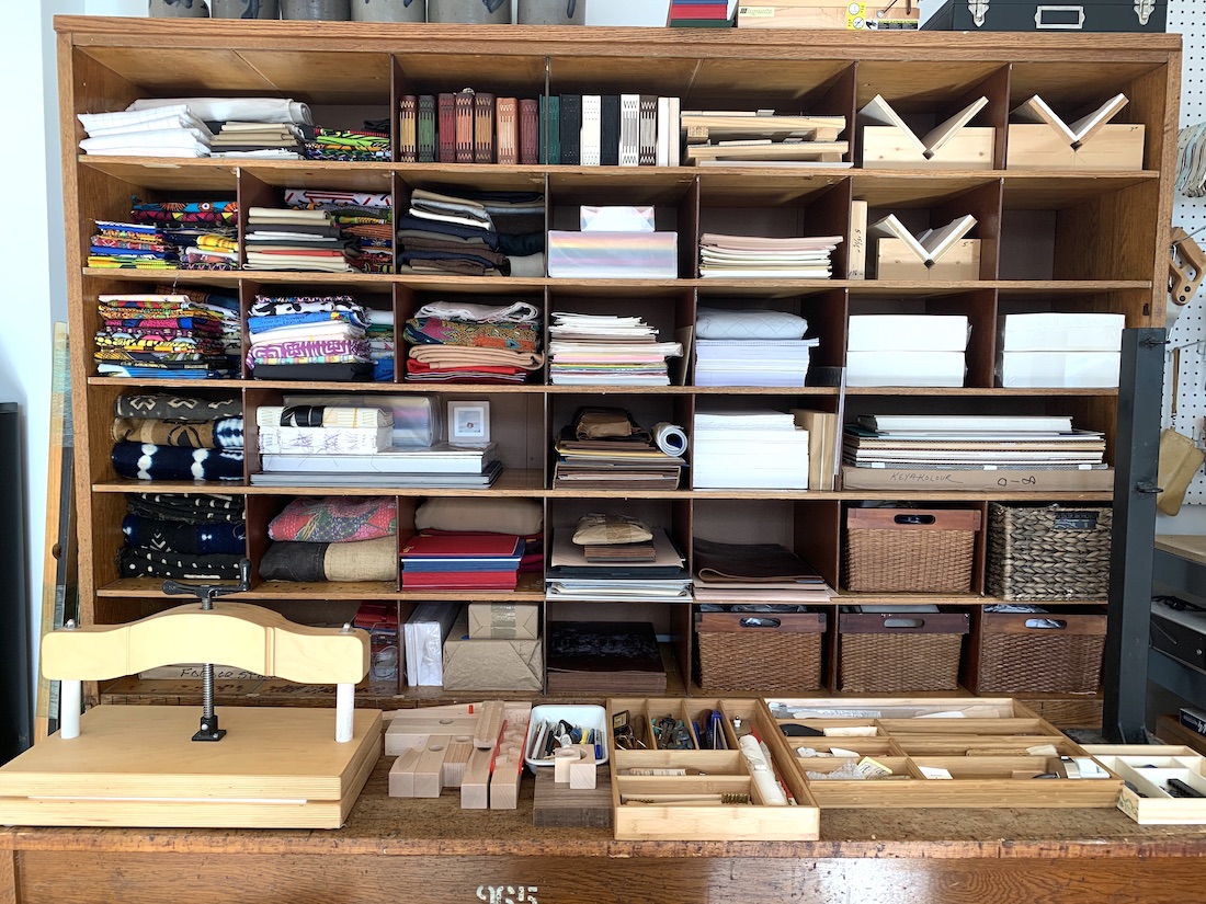 Antique bench filled with bookbinding materials and examples in artist Jonna Twigg's studio