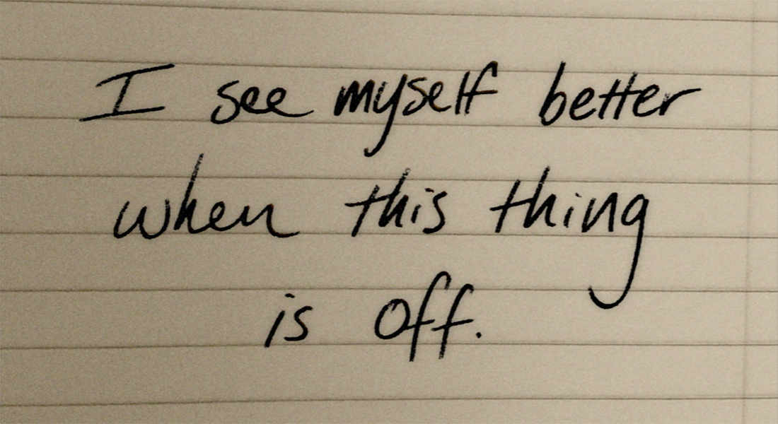 Handwritten note in black ink on notebook paper; it reads, "I see myself better when this thing is off."