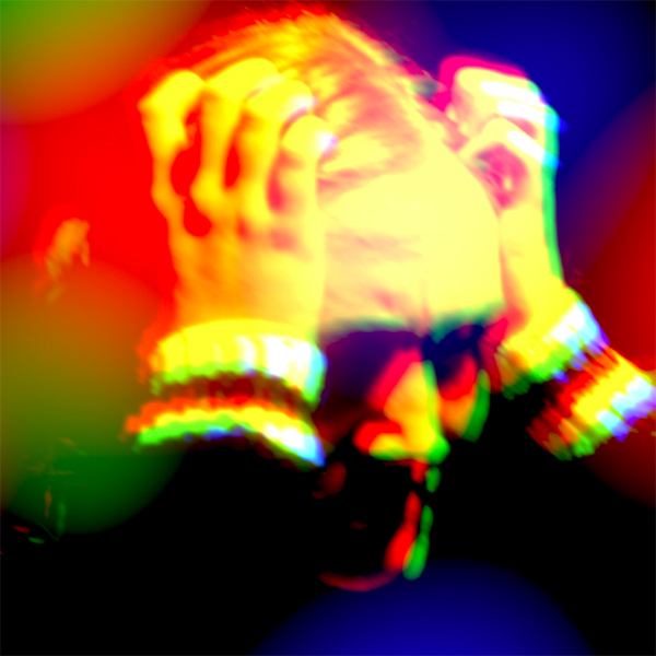 Still of a person gripping their hair with their hands as if in distress; they are lit by a red, yellow, and green filter.
