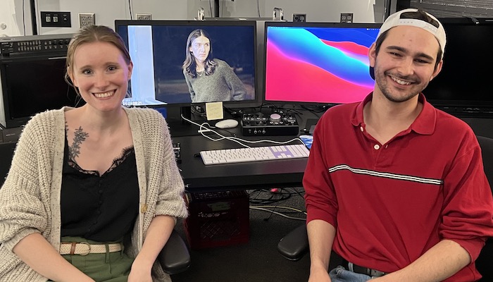 Filmmakers Hannah Blair and Ben Evory sitting in front of two monitors in an editing suite in the Wexner Center Film/Video Studio
