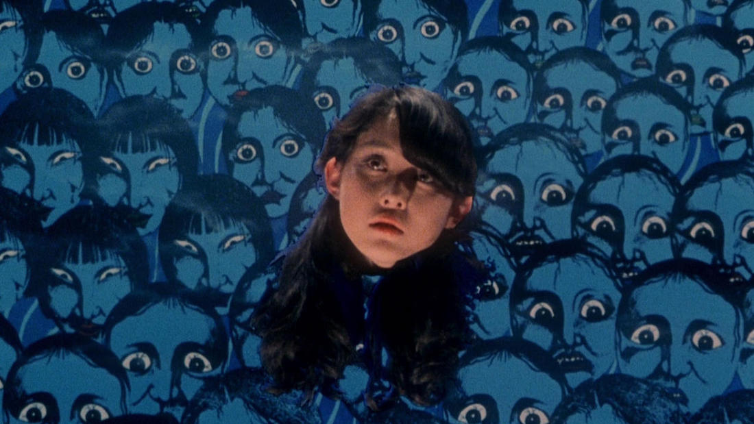 Still from the 1977 Japanese film House. The disembodied head of a young girl with long black hair is at the center. She looks upward, confused and scared. The background is filled with illustrated images of blue faces with wide, frightened eyes.