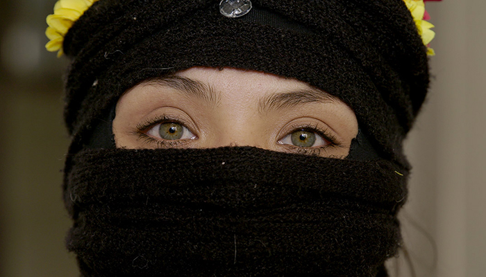 a person's face covered in black fabric except for the eyes