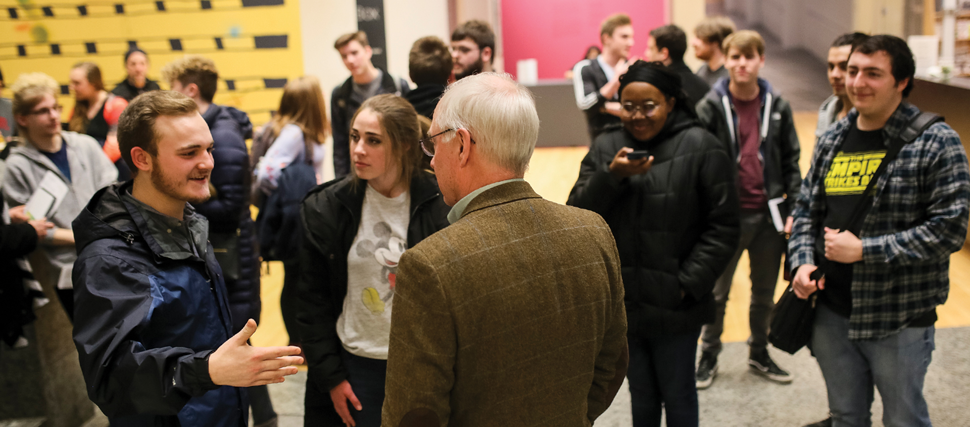 A group of people mingling in the Wex lower lobby