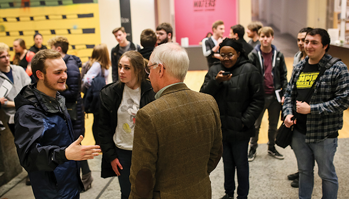 A group of people mingling in the Wex lower lobby