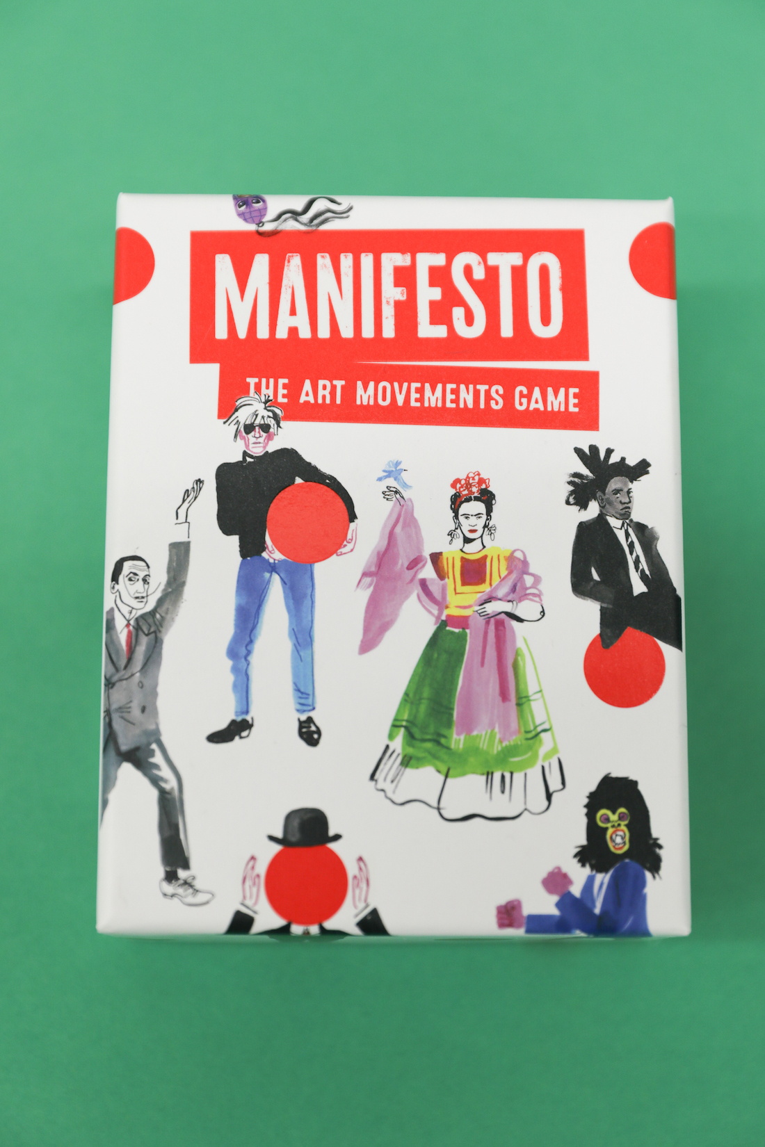 The cover for Manifesto: The Art Movements Game. It features illustrations of Salvador Dali, Andy Warhol, Frida Kahlo, Jean-Michel Basquiat, and a Guerilla Girl, as well as a reference to Rene Magritte's Man in a Bowler Hat..