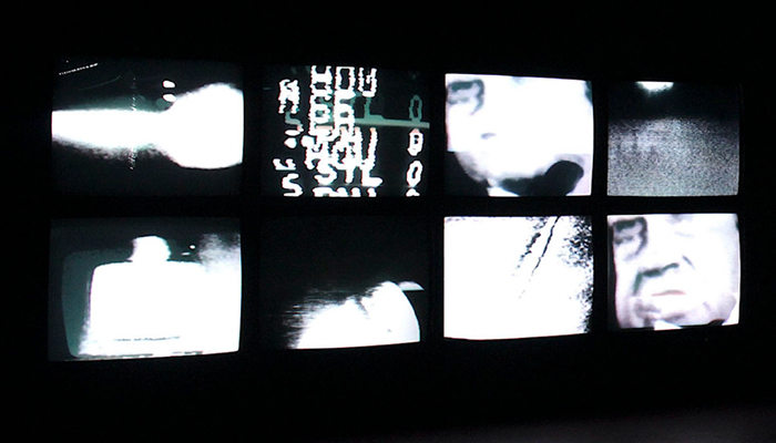 A row of black-and-white television screens displaying Richard Nixon and other abstracted images.
