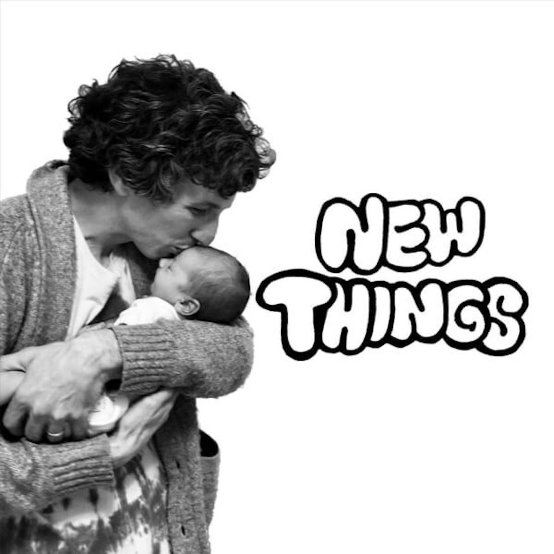 Black and white image of a man with lightly graying dark hair, seen in profile against a white background. He’s holding an infant close to his chest and placing a kiss on the child’s forehead. The words "NEW THINGS" are to the right in balloon-like handwriting.