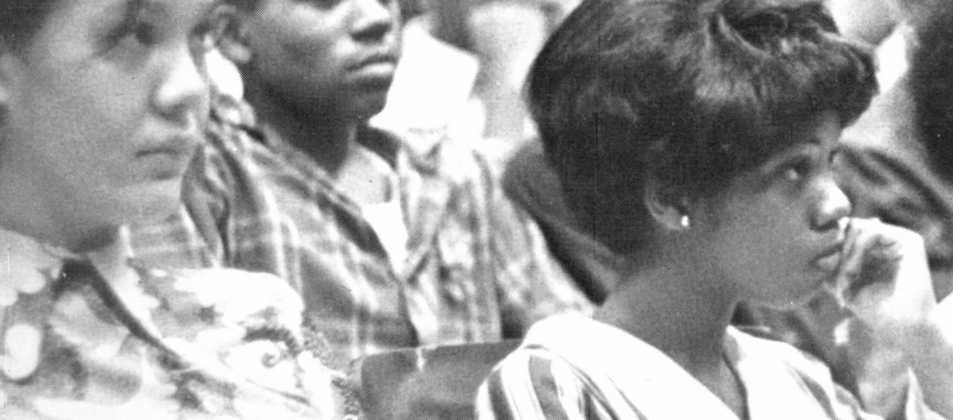 Archive black and white close-up of three high school students looking forward and listening.