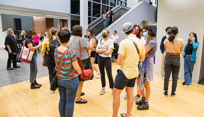 A crowd of people stand and mingle at the Wexner Center.