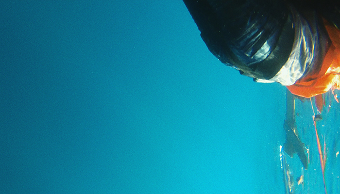 A disorienting color image that seems to be of a figure underwater. 