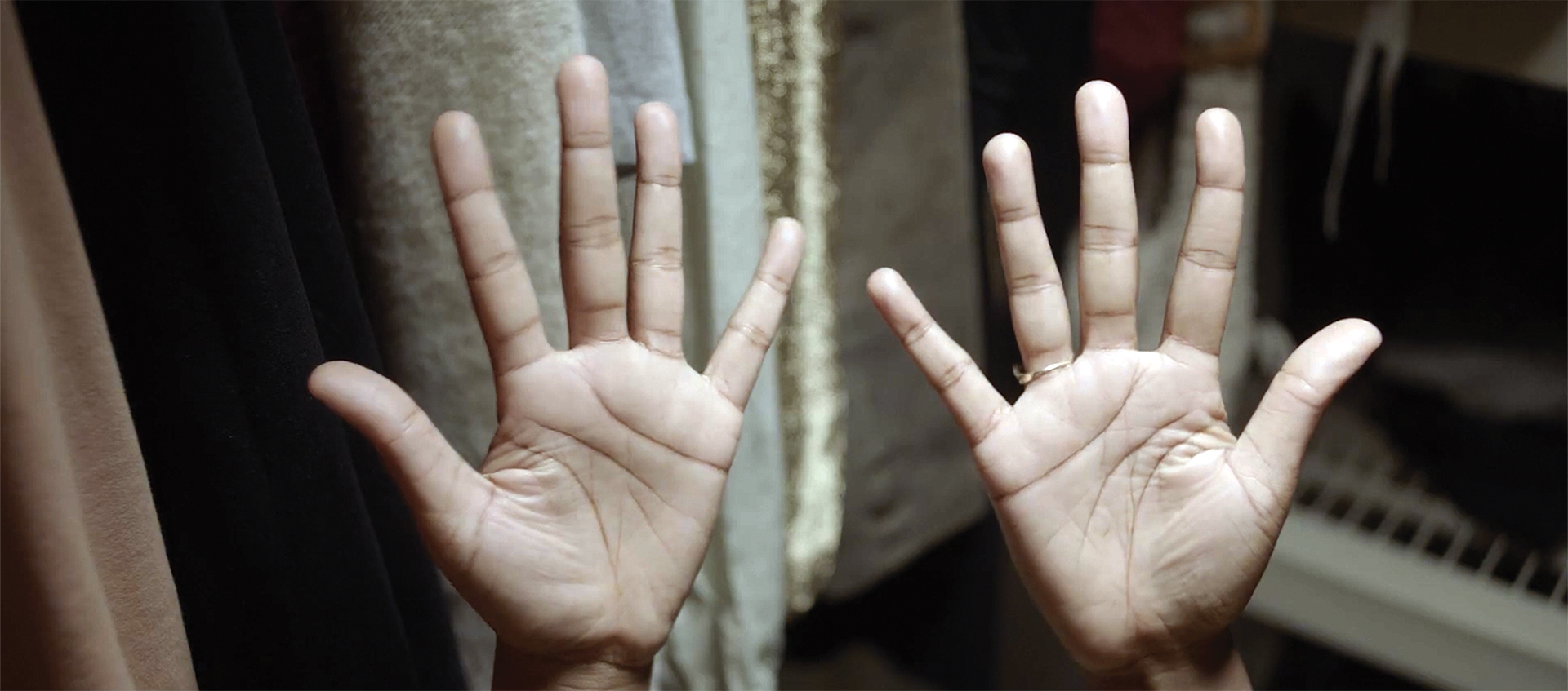 Close-up of Black, deaf actor Nyeisha Prince’s hands, which are held upright with their palms facing the camera.