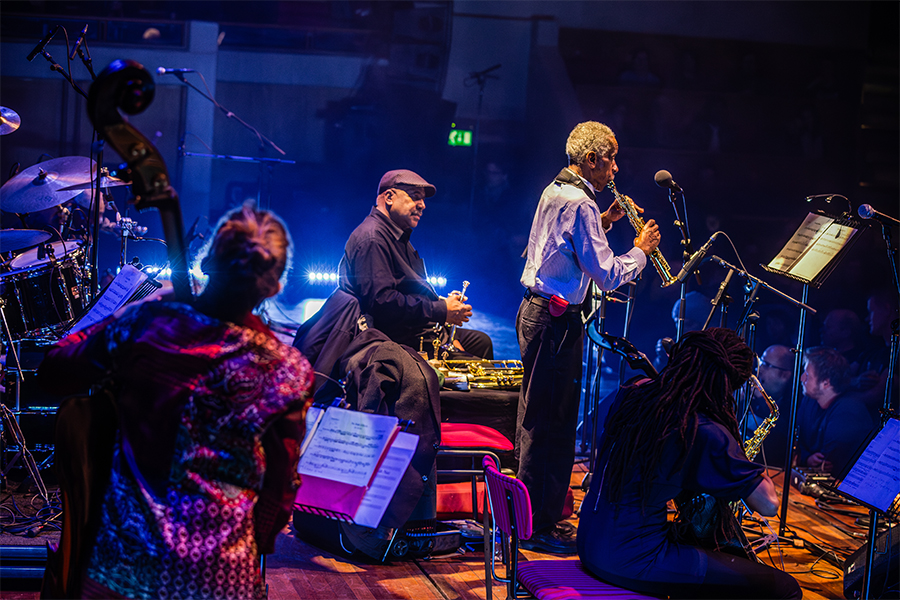 A view of the Art Ensemble of Chicago performing, taken from stage left. Roscoe Mitchell stands center stage.