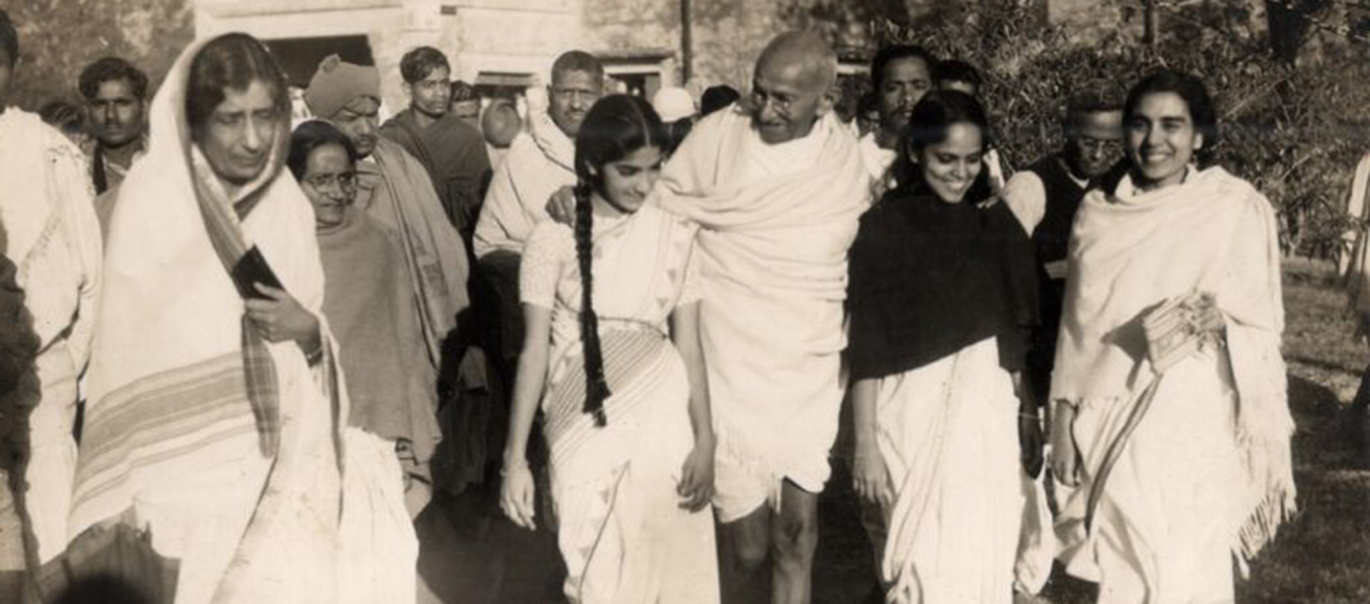 black and white image of a group of people dressed in traditional Indian garb.