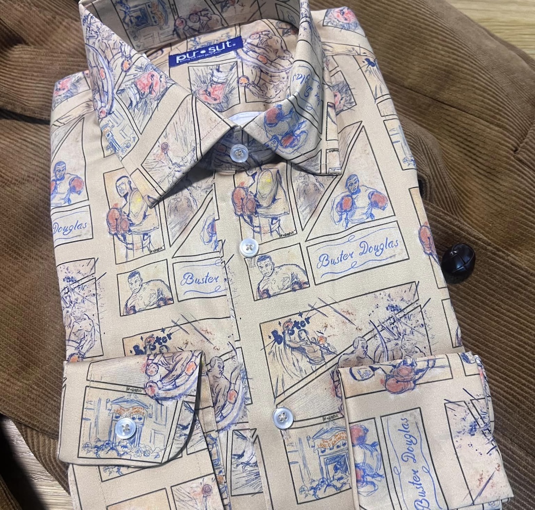 A pictured of a folded button-down shirt adorned with comic panels filled with boxing images