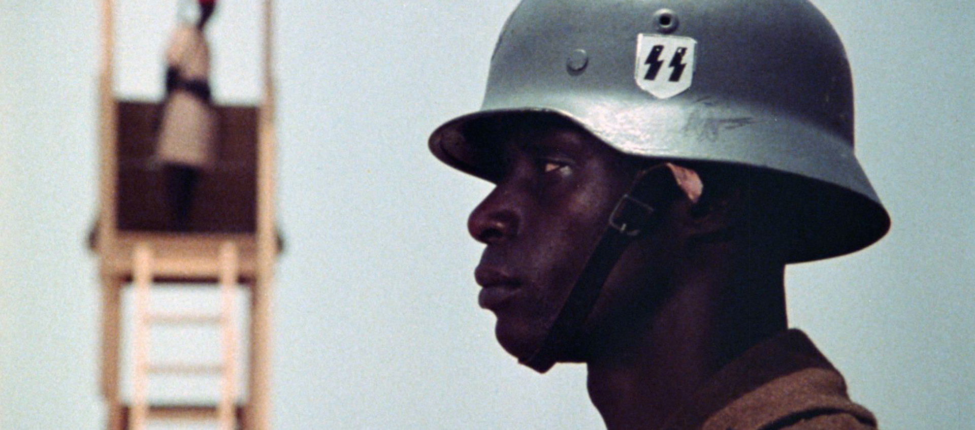 The profile of a Black man wearing a military helmet.