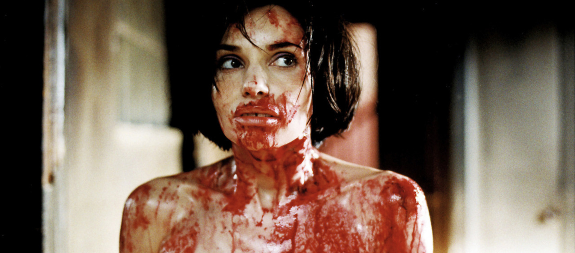 2.	A close up of a woman whose face and shoulders and smeared with blood.
