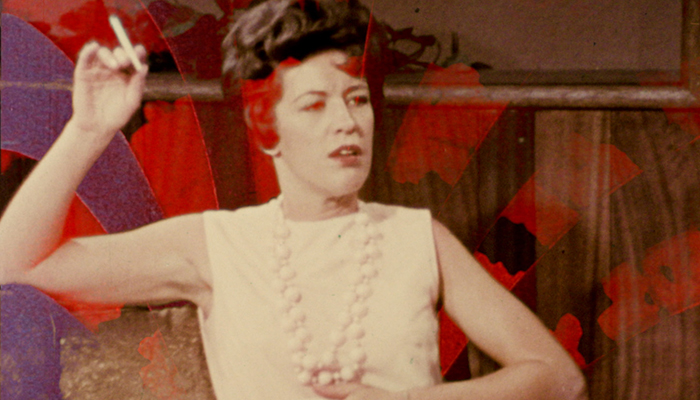 Still of a woman smoking a cigarette. Colors and textures are superimposed over her.