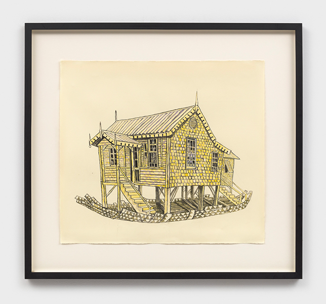 A framed painting of a yellow brick house boat on a gallery wall.