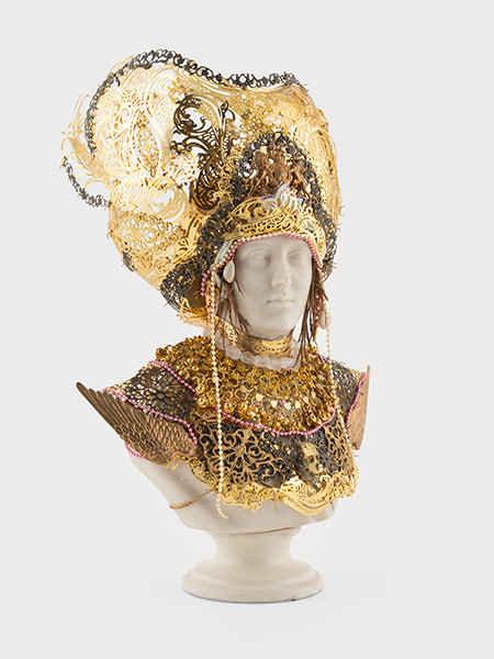 A white bust of Princess Alexandra wearing an ornate golden headpiece and chest armor.