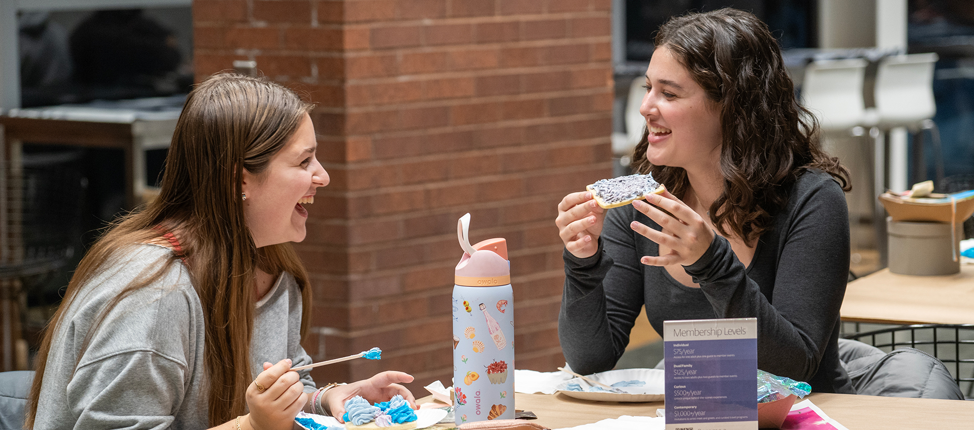 Two young adults sit in Heirloom Café with cookies they decorated.