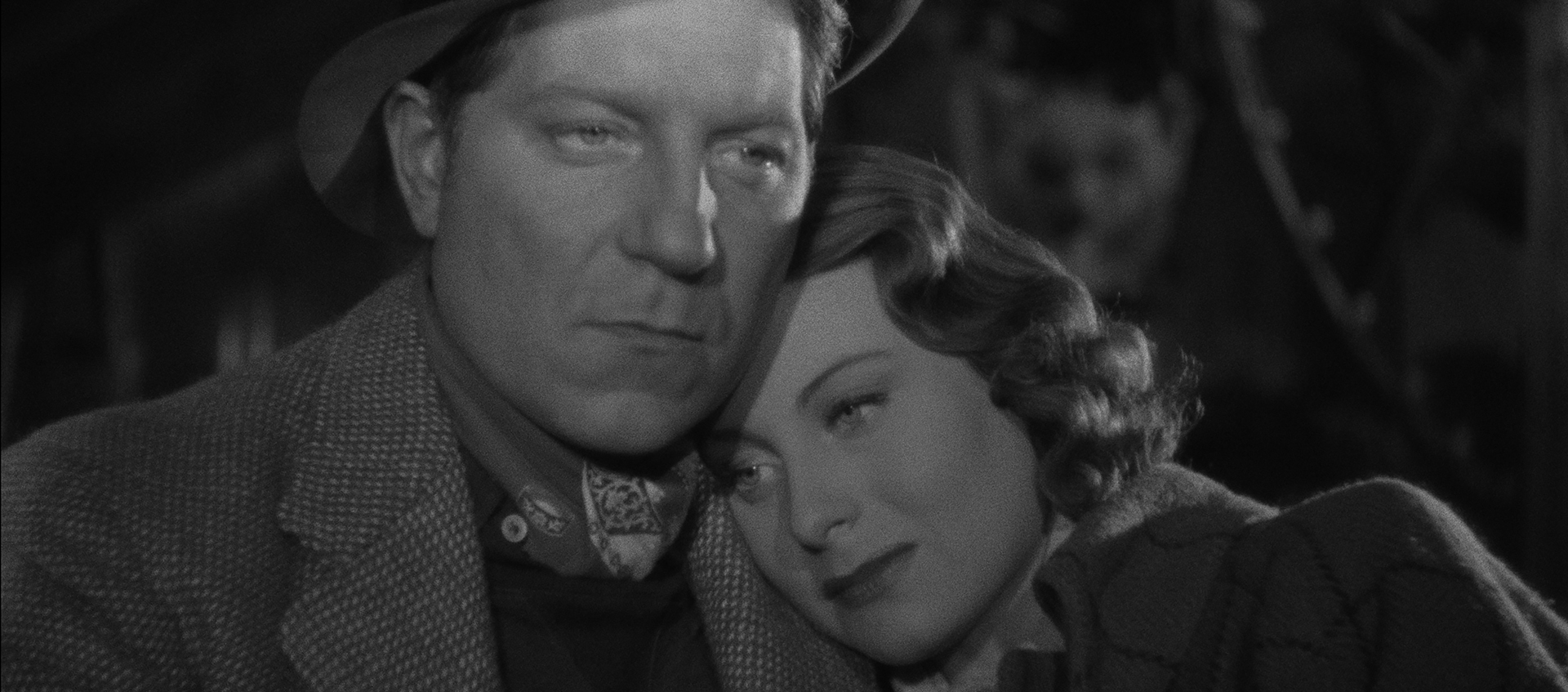 Black and white image of a woman leaning on a man's shoulder.