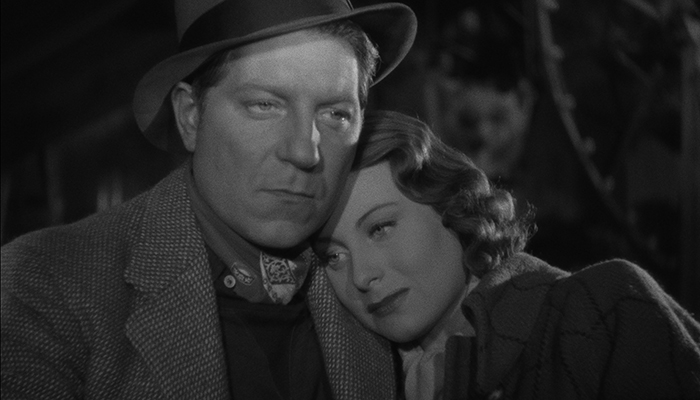 Black and white image of a woman leaning on a man's shoulder.