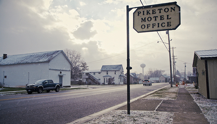 A street of a small town with a sign saying "Piketon Motel Office"