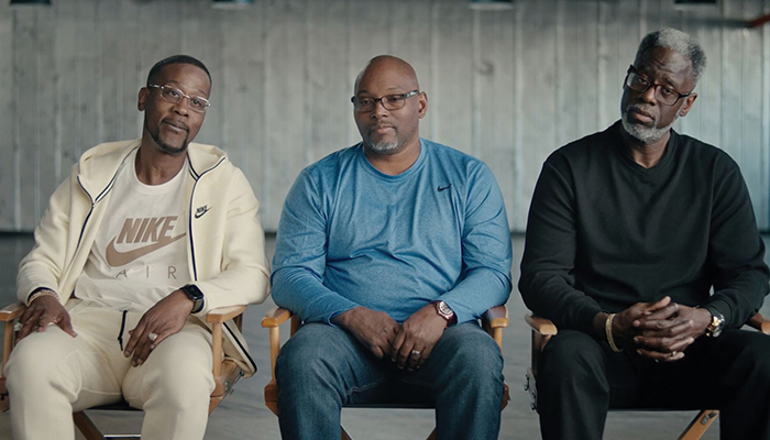 Three men sit in chairs next to each other 